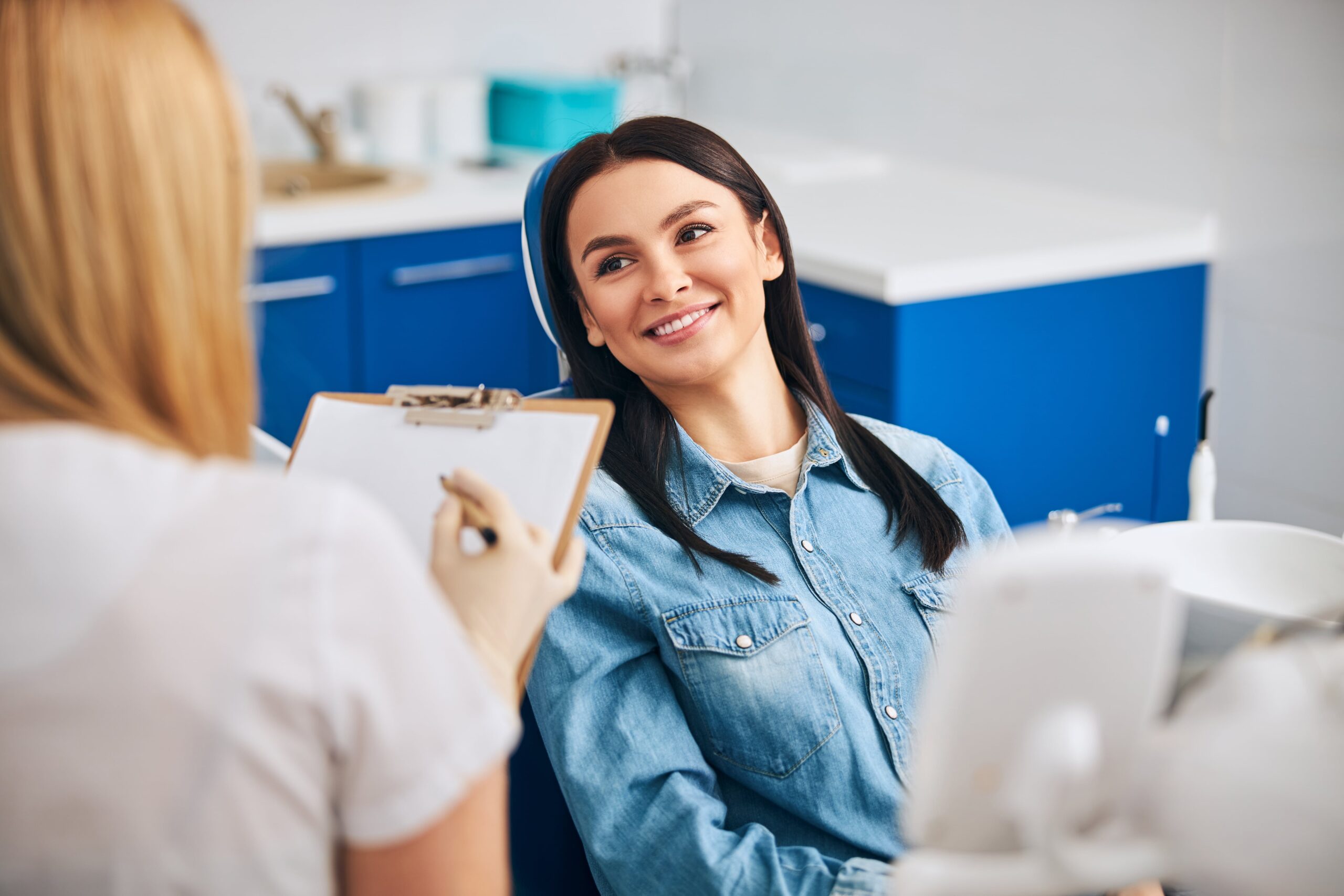 positive delighted brunette being in all ears to the dentist during a dental checkup