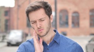 toothache young man with tooth infection in public dental emergency